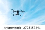 Drone machine with blue sky background for commercial marketing. Drone services for land and environmental assessment, providing reliable aerial insights.
