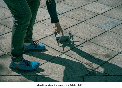 Drone operator pressing the start button on a drone, preparing it for takeoff and flight operation.