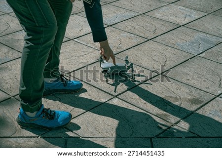 Drone operator pressing the start button on a drone, preparing it for takeoff and flight operation.