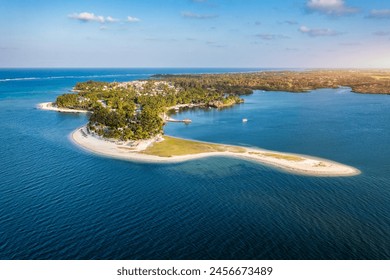 Drone overhead view of the beach of Constance Belle Mare Plage in Mauritius, with palm trees, umbrellas and a beautiful turquoise sea with transparent water. Luxury 5 star hotel in Mauritius.