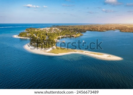 Drone overhead view of the beach of Constance Belle Mare Plage in Mauritius, with palm trees, umbrellas and a beautiful turquoise sea with transparent water. Luxury 5 star hotel in Mauritius.