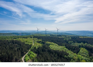 Drone panorama over forest and wind turbines in Germany .