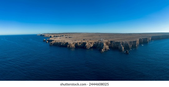 A drone panorama view of the Punta Nati lighthouse and coastal cliffs in northwestern Menorca - Powered by Shutterstock