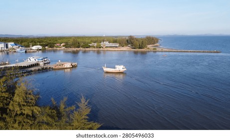 A drone perspective capturing a wide panorama of the shoreline where the river meets the sea, with a military landmark on the distant coast