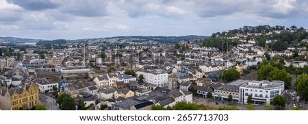 Drone perspective of St Leonard’s Clock Tower in Newton Abbot’s market centre, showing Gothic stone tower, clock faces, shops and pedestrian zone