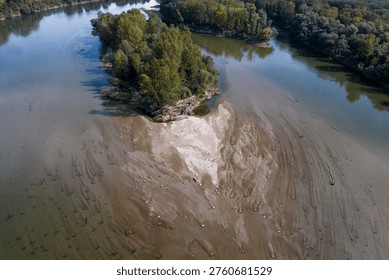 Drone perspective of two large forested islands in the Drava River with receding water levels and extensive sand dunes visible on the riverbed