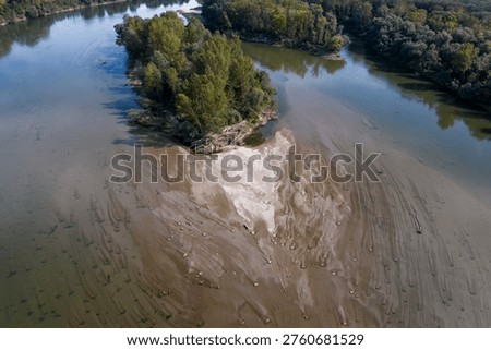 Drone perspective of two large forested islands in the Drava River with receding water levels and extensive sand dunes visible on the riverbed