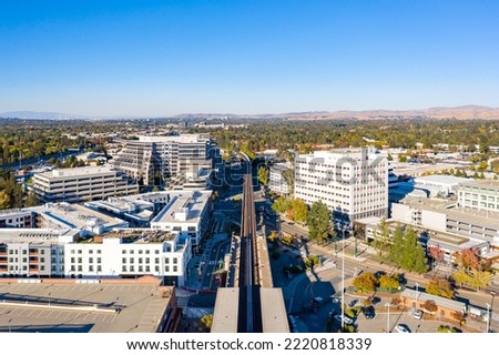 Drone photo above bart tracks in Walnut Creek, California with office building and a blue sky with room for text