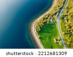 Drone photo of the blue sea and green grass in the middle of Norway. Beautiful Autumn colours in Scandinavia captured from the bird perspective.