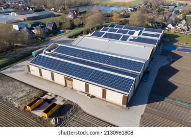 Drone photo of modern solar panels on a commercial building. Solar panels provide cheap solar energy. - Shutterstock ID 2130961808