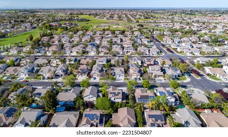 Drone photo over a suburban neighborhood in Brentwood, California with rows of houses with solar panels.  - Powered by Shutterstock