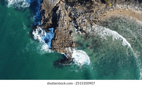 Drone photo showing rocky headland and beach with ocean waves. Bright blue green ocean waves. Early morning light.  - Powered by Shutterstock