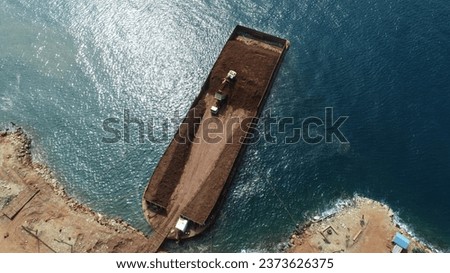 Drone photo view of loading and shipping activities in the laterite nickel ore mining industry, Kabaena Island, Indonesia.