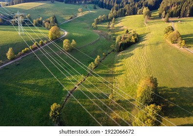 Drone photography of the power line over a green meadow. Green energy.