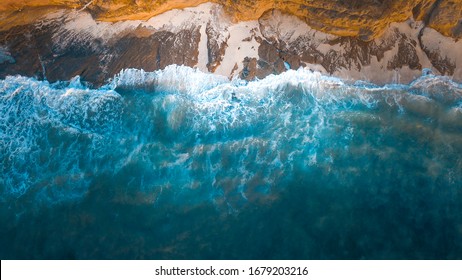 Drone photography. We see how the sea collides with the stones and sand of a beach in México.