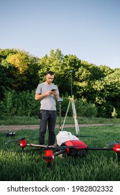 A Drone Pilot Configuring His Drone In A Field With And Irrigation System Before Flying