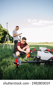 A Drone Pilot Configuring His Drone In A Field With And Irrigation System Before Flying