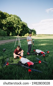 A Drone Pilot Configuring His Drone In A Field With And Irrigation System Before Flying