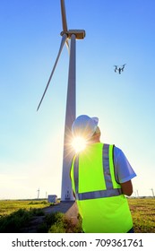 Drone Pilot Operating Wind Turbine Inspection At Sundown