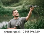 Drone pilot teacher holding UAV during outdoor lesson