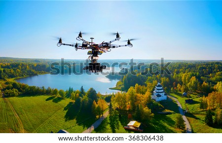 drone with professional cinema camera flying over a autumn park in fall colors under morning light with deep long shadows