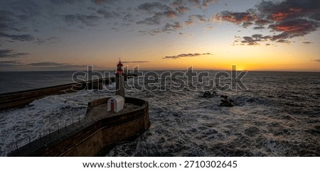 Drone push in passing lighthouse Farol da Barra do Douro, Foz do Douro, Porto, Portugal, at sunset