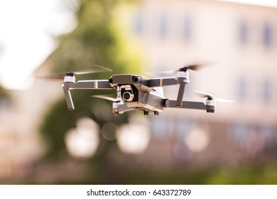 drone quad copter with high resolution digital camera flying hovering over the city