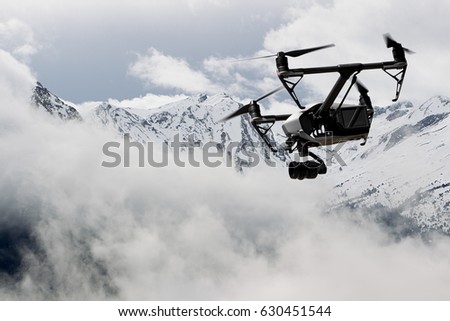 drone quad copter with high resolution digital camera flying over the snowy mountain 