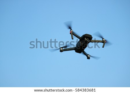 Drone / Quadcopter with camera flying on a clear sky background