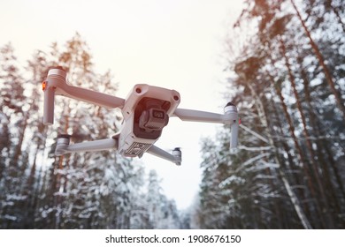 Drone quadcopter with camera flying in the winter forest