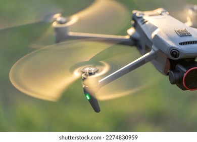 Drone quadcopter with digital camera and fast rotating propellers flying taking video and pictures - Shutterstock ID 2274830959