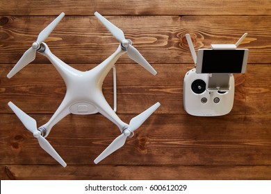 Drone quadcopter with a flight controller on the old wooden background with a copy space. Top view, flat lay composition.