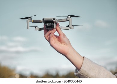 Drone quadrocopter taking off from man hands outdoors. Young man releasing aerial copter to fly with small digital flying camera. Concept of modern technology in our life. Copy space for site