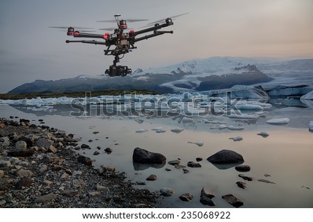 A drone with raised landing gears and a camera flying over icebergs with a glacier in the background 