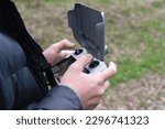 Drone remote control with a screen in male hands, close-up photo.
