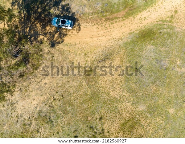Drone return to home view overhead\
as it comes in to land beside a vehicle in the\
bush.