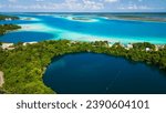 drone revealing cenote in Bacalar Mexico with 7 colours lagoon Quintana Roo Mexican resort beach town travel holiday destination 