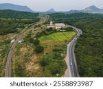 drone shot aerial view top angle panoramic photograph electric railway train track broadguage passing through tunnel mountain pass hilly terrain valley western ghats transportation india theni-madurai