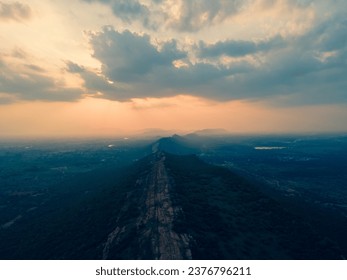 drone shot aerial view top angle panoramic photograph of long mountain range sunset dusk hill cliff peak summit terrain rugged rocky trekking hiking trail forest Nagamalai madurai india jungle  - Powered by Shutterstock