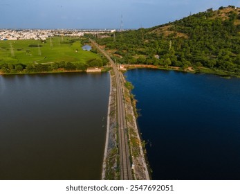 drone shot aerial view top angle sunset dusk railway track natural scenery india tamilnadu turquoise blue water wallpaper background town lake irrigation reservoir dam canal channel mountain hills  - Powered by Shutterstock