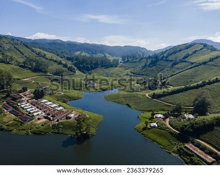 drone shot aerial view top angle photo holiday hill mountain range lake tea plantations megamalai forest tourism sunshine wallpaper background turquoise blue water munnar ooty india village vacation 