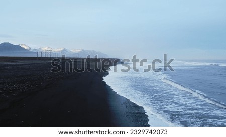 Drone shot of atlantic ocean with black sand beach in icelandic scenery, fantastic nordic landscape with coastline in iceland. Arctic country with majestic nature and scenic route. Slow motion.