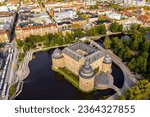 A drone shot of the beautiful Orebro Castle surrounded with Svartan river and the cityscape of Sweden