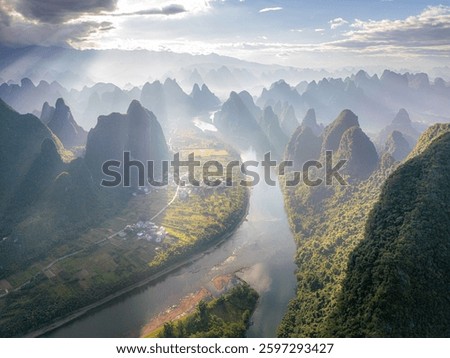 Drone shot of the first rays of light through the clouds in Xianggong hill landscape of Guilin, Li River and Karst mountains. Xingping, Yangshuo County, Guangxi Province, China