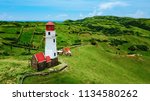 Drone shot of Mahatao Tayid Lighthouse on top rolling hills in the province of Batanes, Philippines