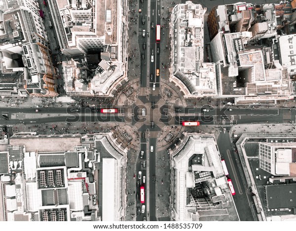 Drone shot of Oxford Circus during the day, with\
cars and red buses