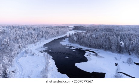 Drone shot of a partly frozen river in a snowy landscape in Lapland - Powered by Shutterstock