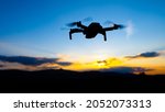 Drone silhouette at sunset time. Unmanned aerial vehicle, UAV, or uncrewed aerial vehicle.