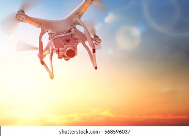 The drone in the  sunset sky. Close up of quadrocopter outdoors.