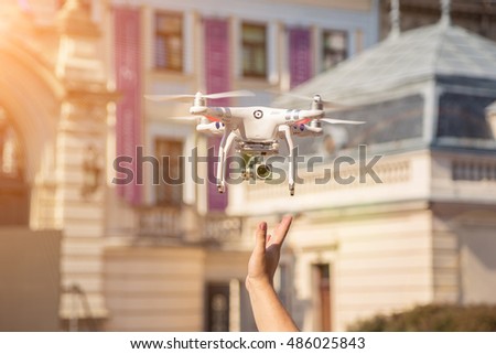 Drone is taking off from men hands. Young men releasing copter to fly in the sunset field. Modern technology in our life.
